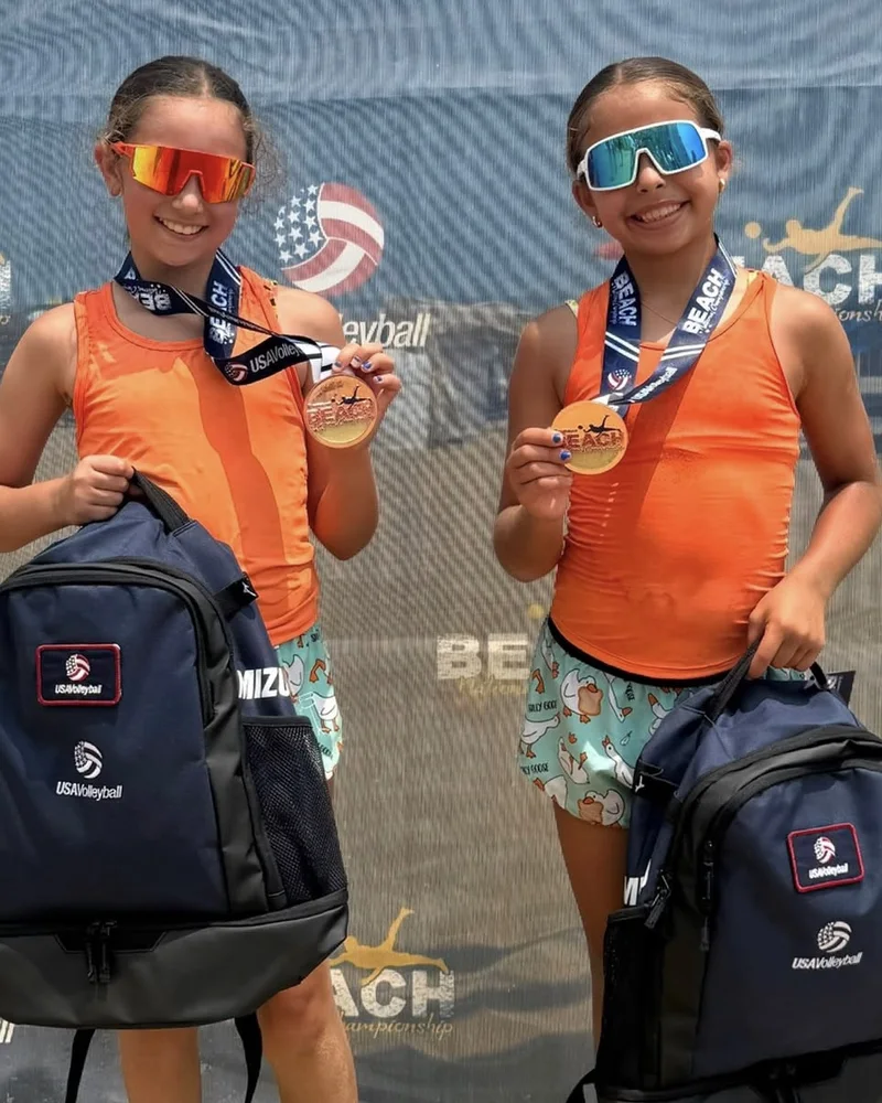 Camila Salcedo and Bella Mustelier holding their USA Volleyball Beach National Championship medals