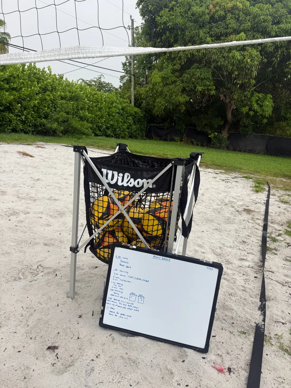 Court equipment and a coaching board set up on the sand before a session