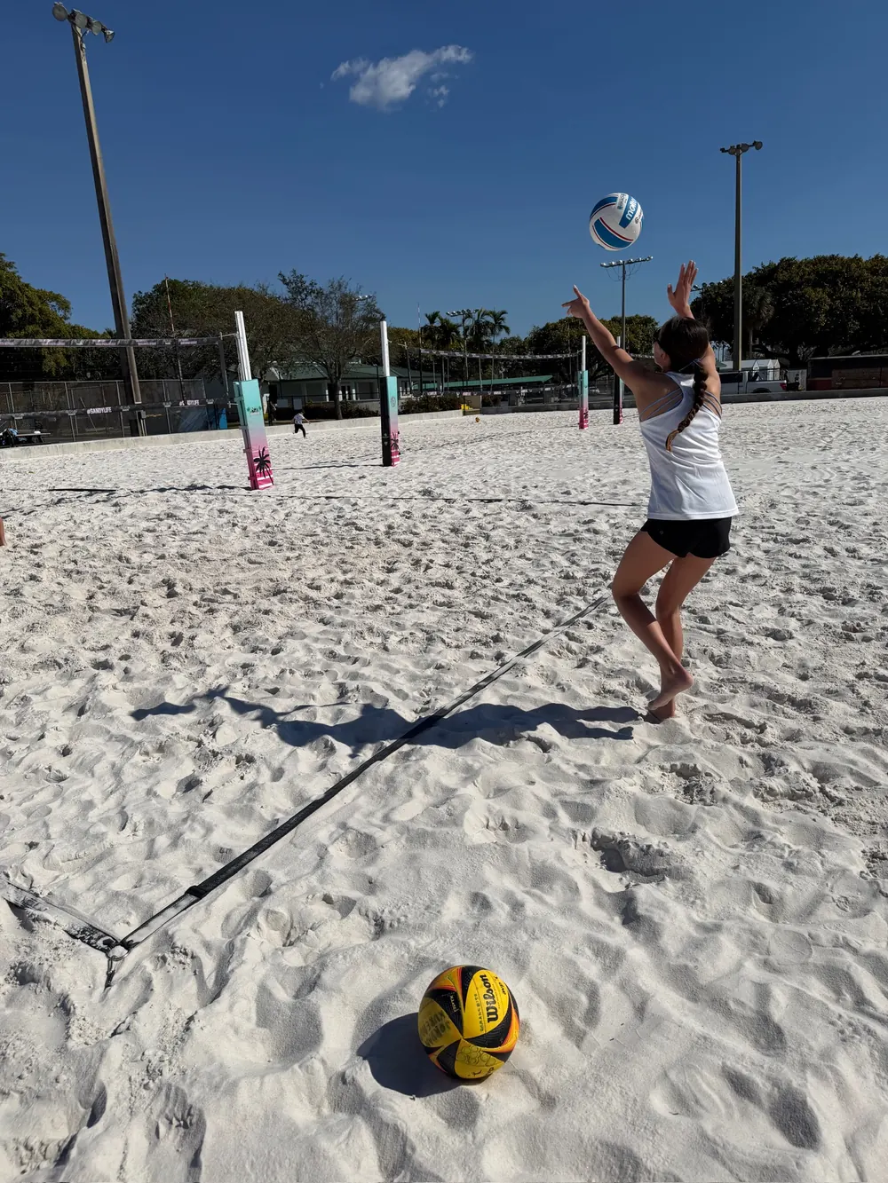 A Mamu Beach athlete rising for a swing during a training rally