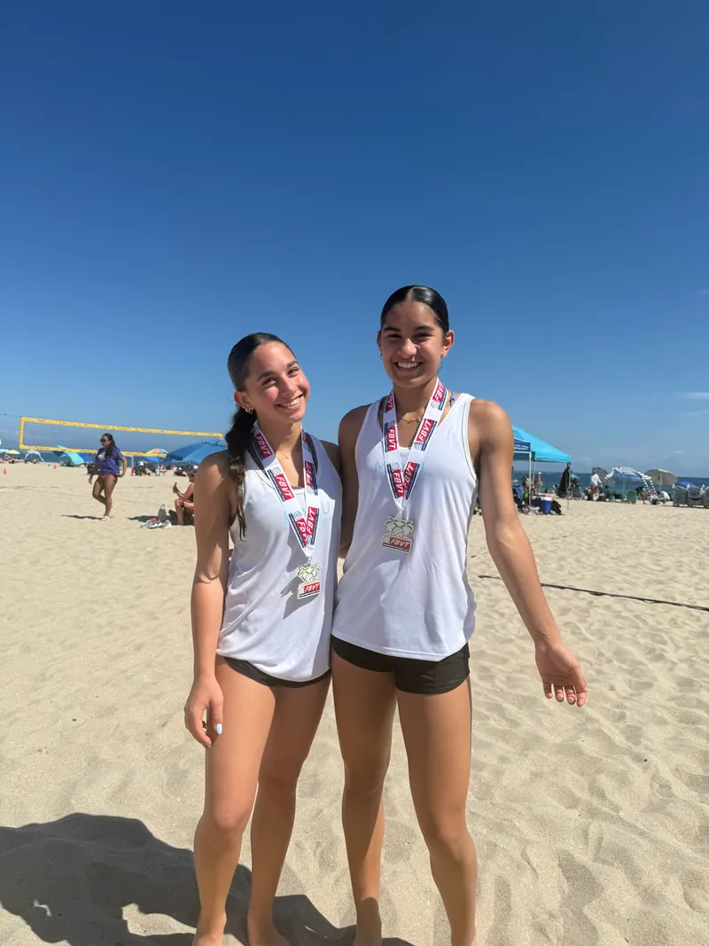 Two Mamu Beach athletes on the open beach wearing Florida Beach Volleyball Tour medals